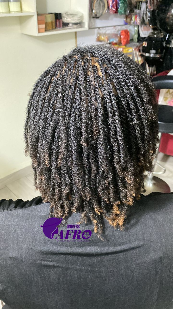 Femme avec coiffure afro naturelle dans un salon de Dakar